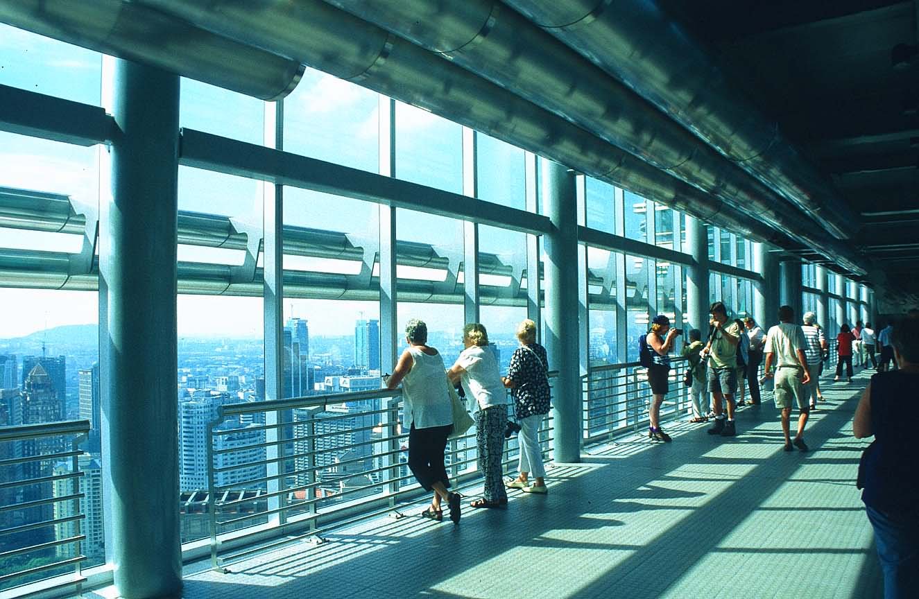 Tourist Enjoying View From Inside Skybridge Petronas Towers