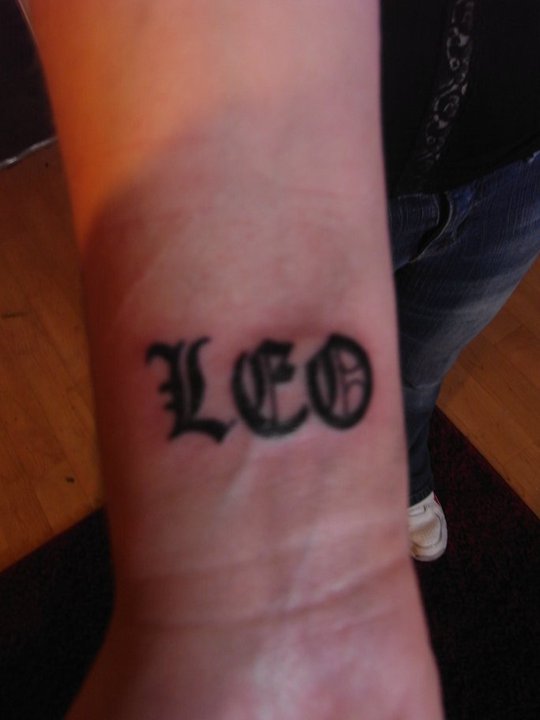 Amazing Black Leo Lettering Tattoo On Wrist