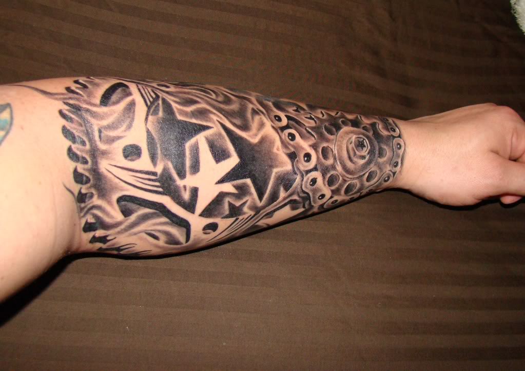 Black And Grey Motorcycle Chain Sprocket Tattoo On Arm