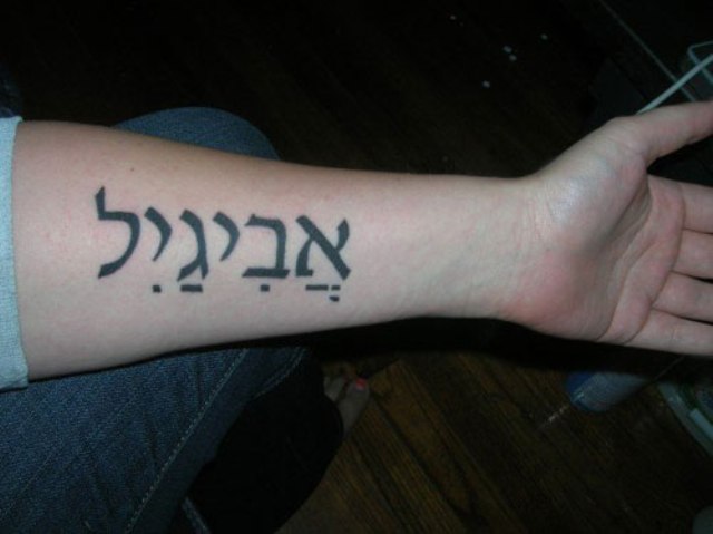 Black Hebrew Lettering Tattoo On Left Forearm