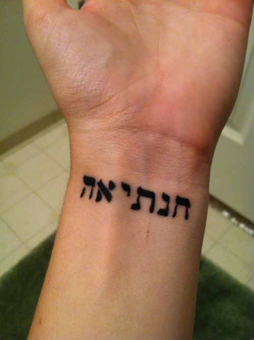 Black Hebrew Lettering Tattoo On Left Wrist