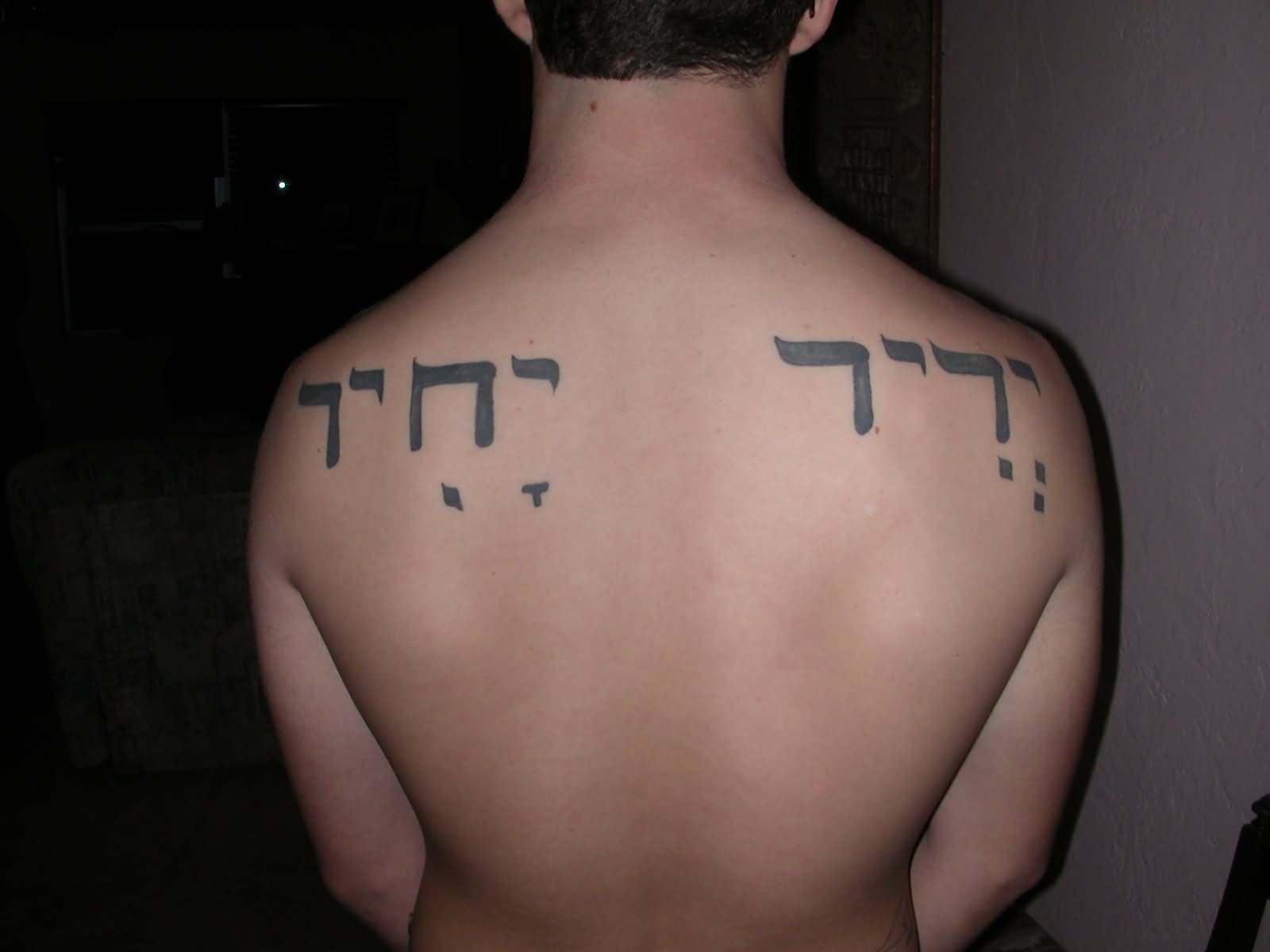 Black Hebrew Lettering Tattoo On Man Upper Back
