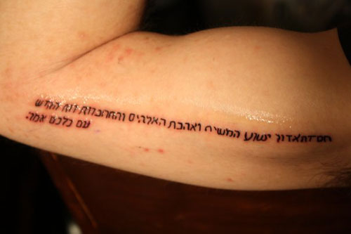 Black Hebrew Lettering Tattoo On Upper Arm