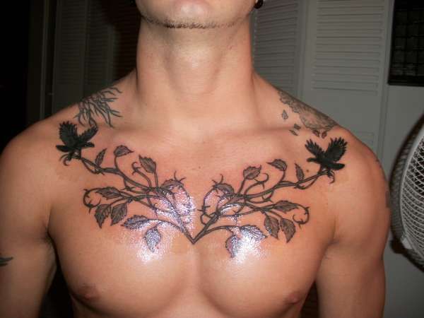 Black Ink Leaves Vine Tattoo On Man Chest