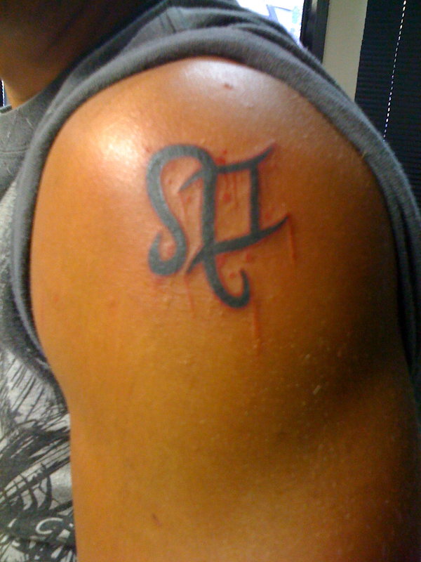 Black Leo Symbol Tattoo On Guy Left Shoulder By Alexander