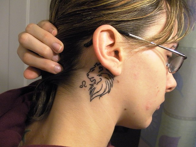 Black Outline Leo Tattoo On Girl Behind The Ear