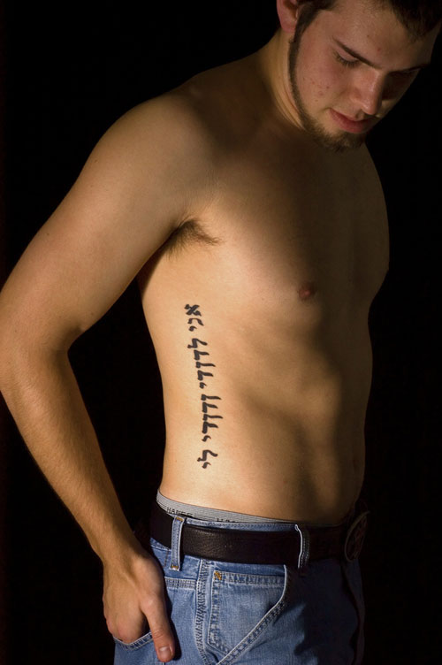 Hebrew Lettering Tattoo On Man Right Side Rib