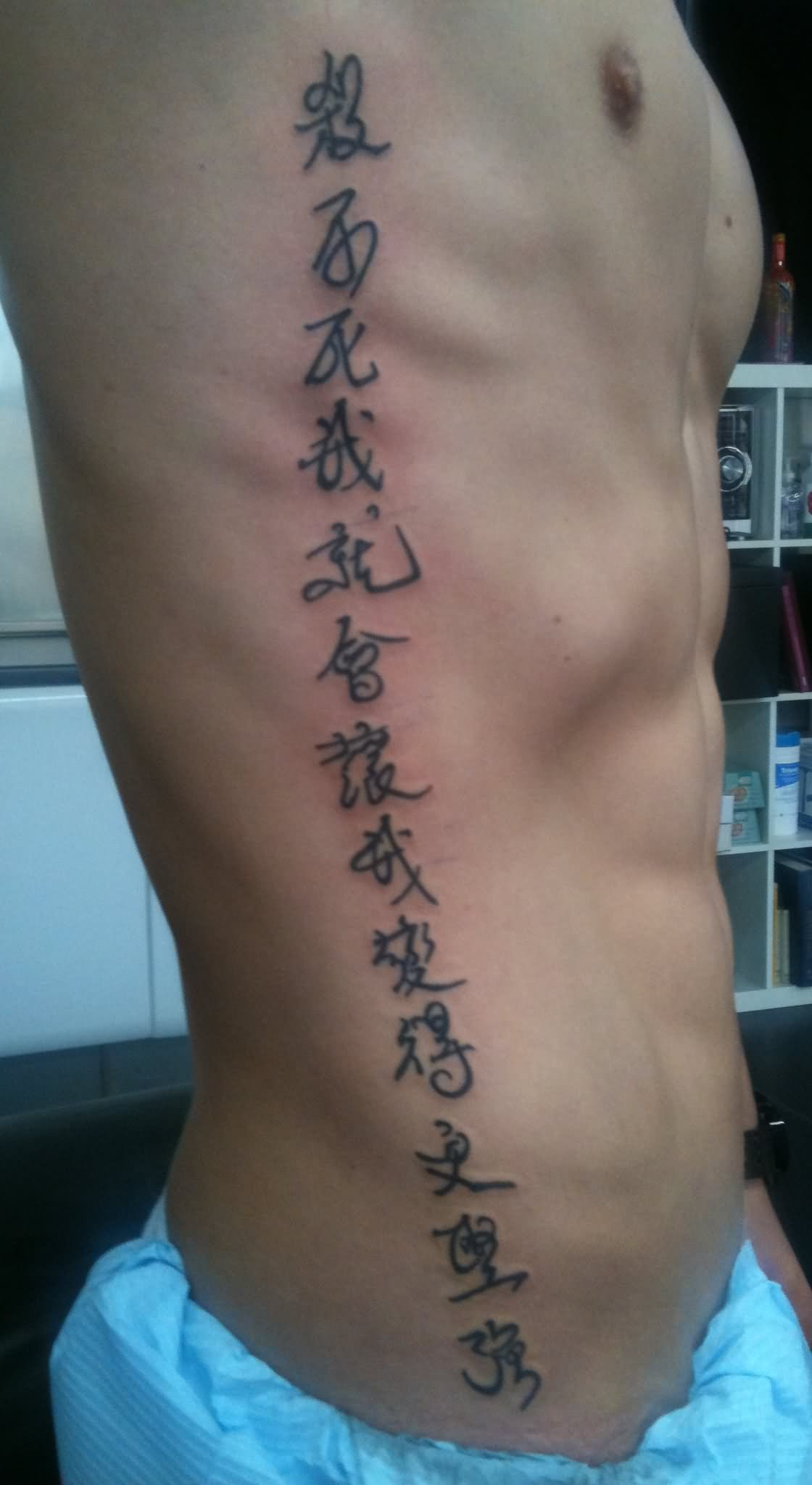 Hebrew Phrases Lettering Tattoo On Man Right Side Rib