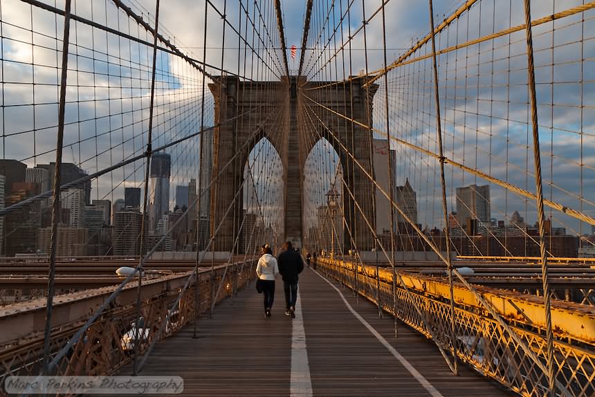 People Walking On The Brooklyn Bridge At The Time Of Sunset