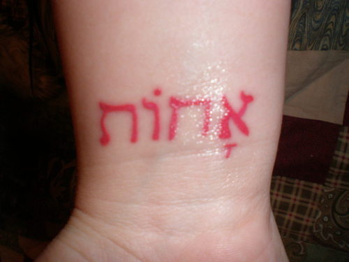 Red Hebrew Lettering Tattoo Design For Wrist