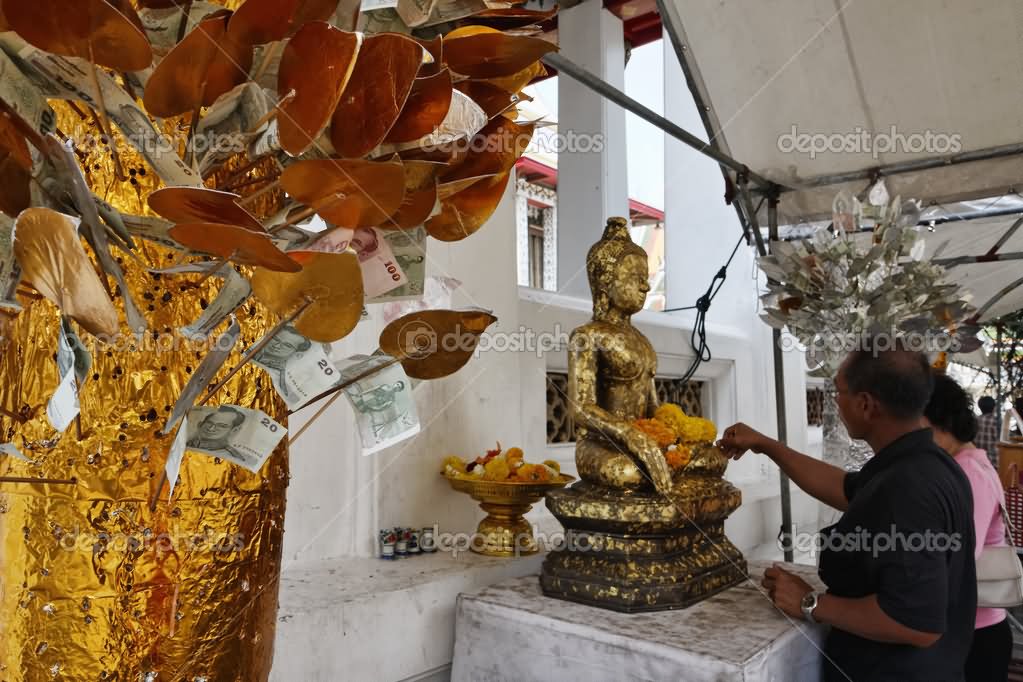 Thai Couple Offering Flowers To Buddha Statue Inside Wat Arun Temple