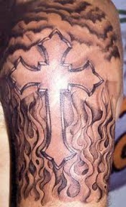 Black And Grey Cross In Fire And Flame Tattoo On Man Left Shoulder