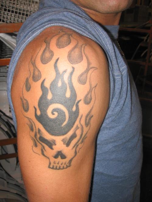 Black And Grey Skull In Fire And Flame Tattoo On Man Right Shoulder