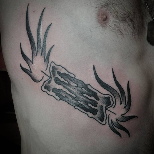 Black and grey ink candle burning at both ends tattoo on siderib