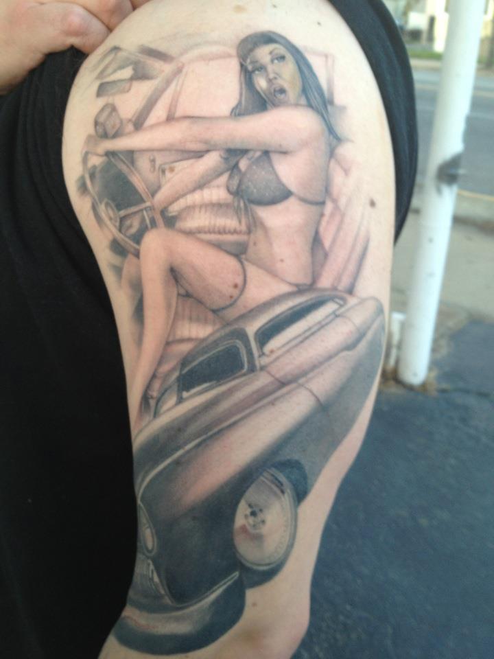 Grey Ink Pinup Girl And Car Tattoo On Left Half Sleeve