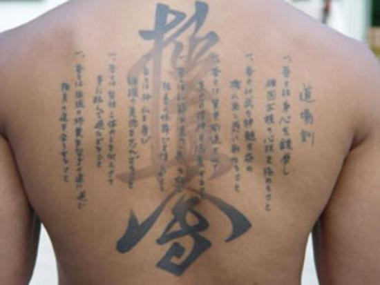 Kanji Lettering Tattoo On Upper Back