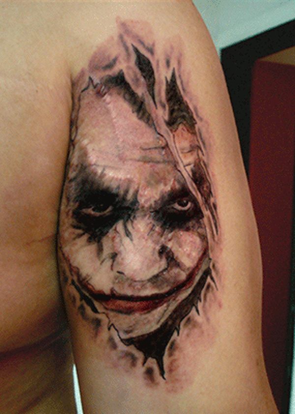 Ripped Skin Joker Tattoo On Bicep