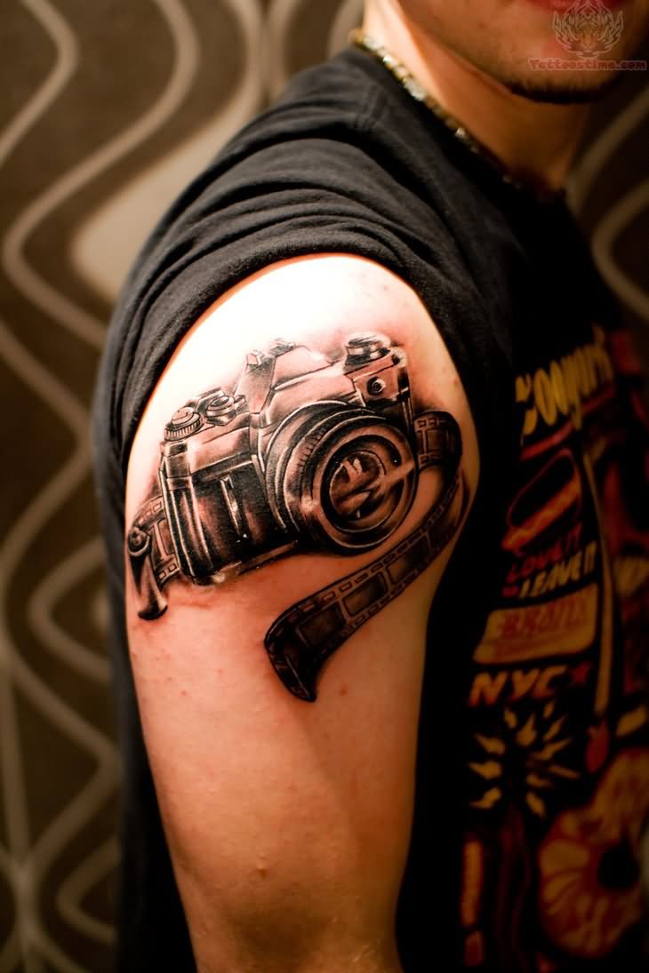 Black And Grey Film Strip With Camera Tattoo On Right Shoulder