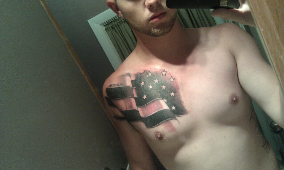 Black And Grey International Flag Tattoo On Right Front Shoulder
