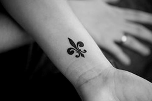 Black Ink Fleur De Lis Tattoo On Left Wrist