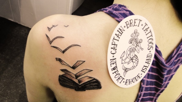 Black Ink Literary Book Tattoo On Left Back Shoulder