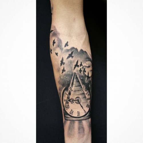 Black Ink Pyramid With Clock Tattoo On Forearm