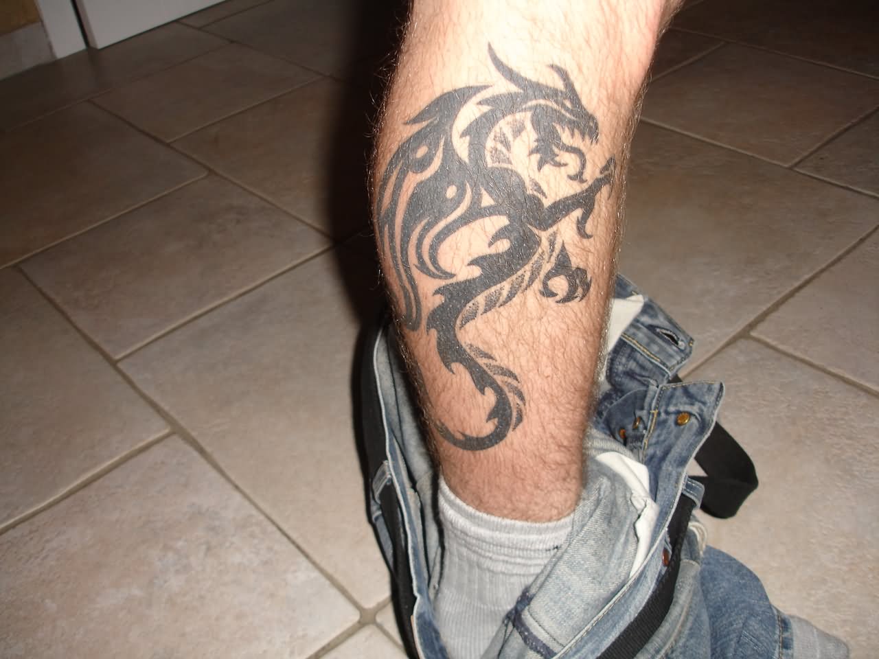 Black Tribal Dragon Tattoo On Right Leg Calf