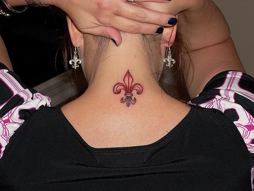 Girl Showing Her Fleur De Lis Tattoo On Nape