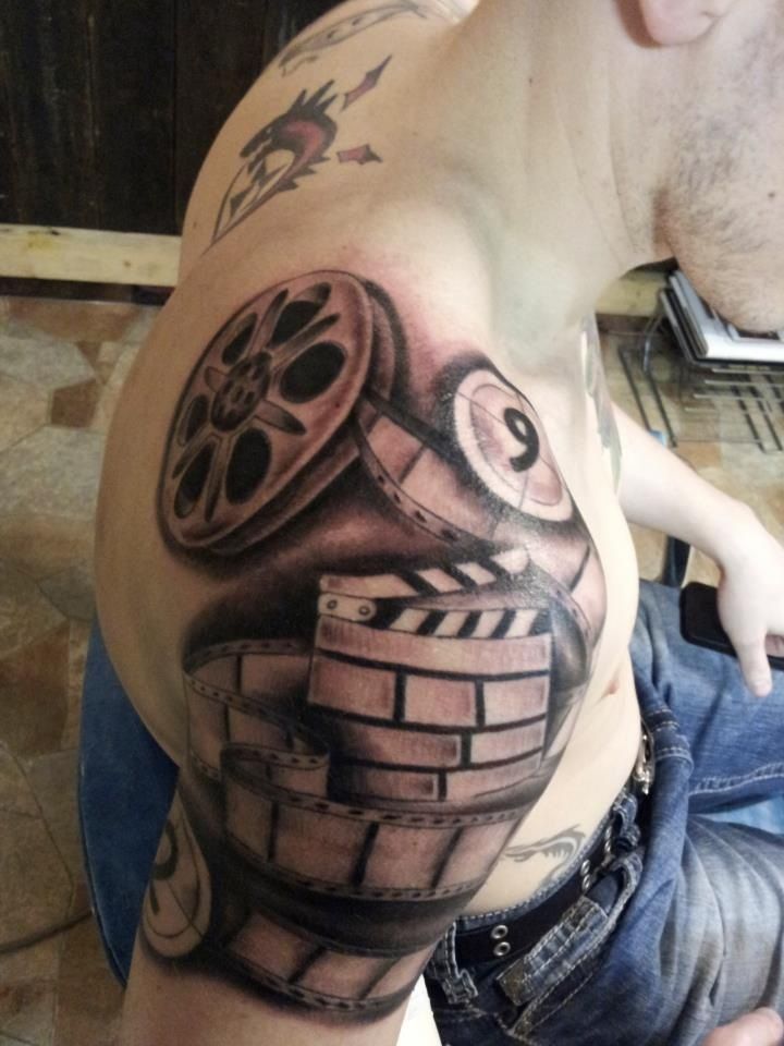 Grey Ink Cinema Tattoo On Man Right Shoulder