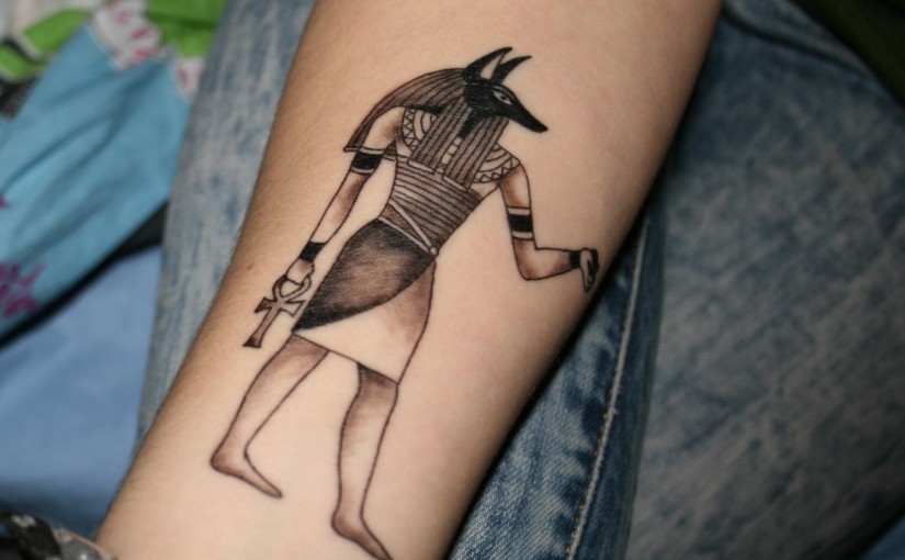 Grey Ink Egyptian Tattoo On Forearm