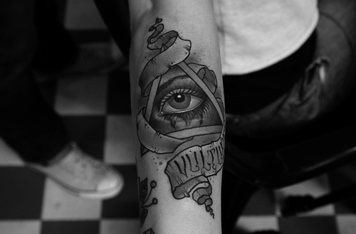Grey Ink Eye In Triangle With Ribbon Tattoo Design