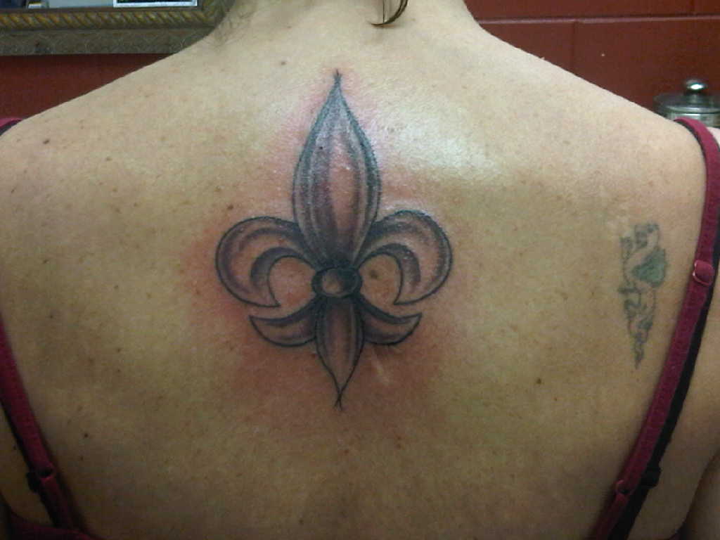 Grey Ink Fleur De Lis Tattoo On Girl Upper Back