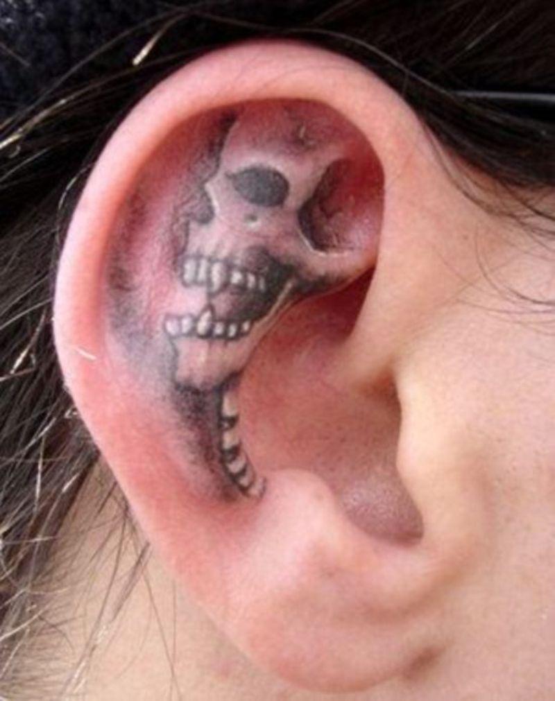 Grey Ink Funky Skull Tattoo On Ear