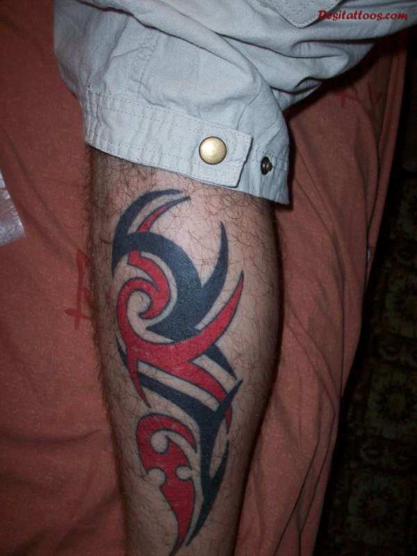 Red And Black Tribal Design Tattoo On Leg