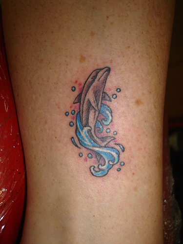 Blue Water Splash And Dolphin Tattoo On Leg