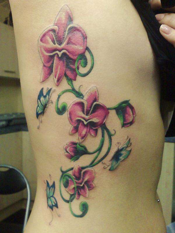 Girl Showing Her Orchid Tattoo On Side Rib