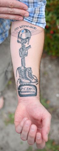 Grey Ink Memorial Military Boots Rifle Helmet Tattoo On Forearm