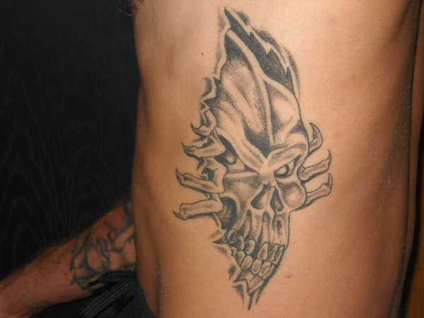Grey Ink Torn Ripped Skin Skull Tattoo Design For Man Side Rib