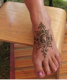 Henna Yin Yang In Flowers Tattoo On Girl Foot