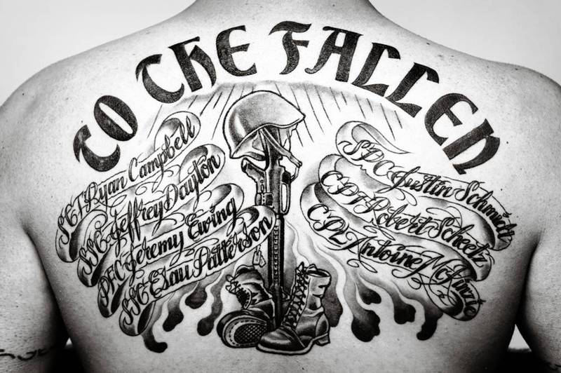 Military Equipments With Banner Tattoo On Upper Back