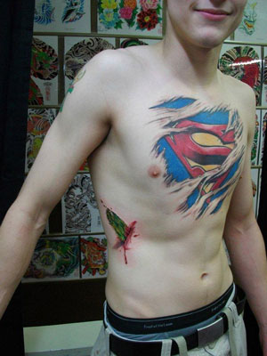 Torn Ripped Skin Superman Logo Tattoo On Man Chest