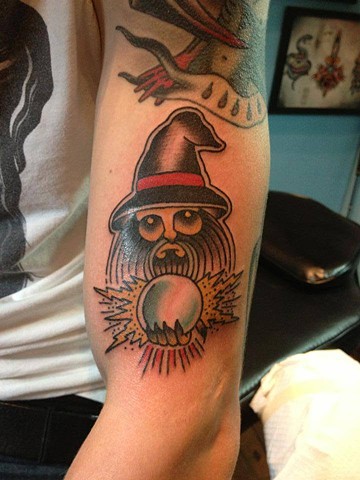 Wizard With Crystal Ball Tattoo On Left Bicep
