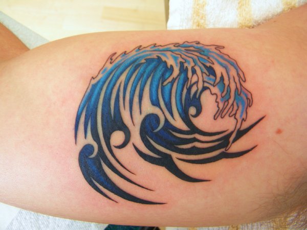 Black And Blue Tribal Wave Tattoo On Bicep