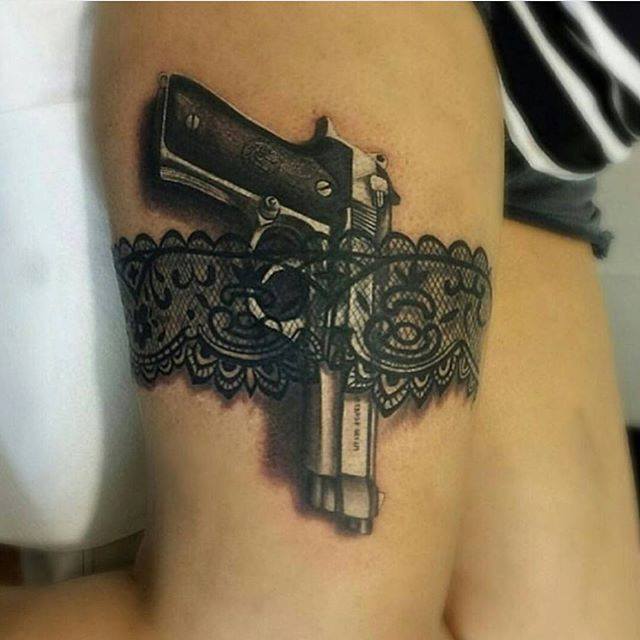 Black And Grey Gun And Belt Tattoo On Thigh