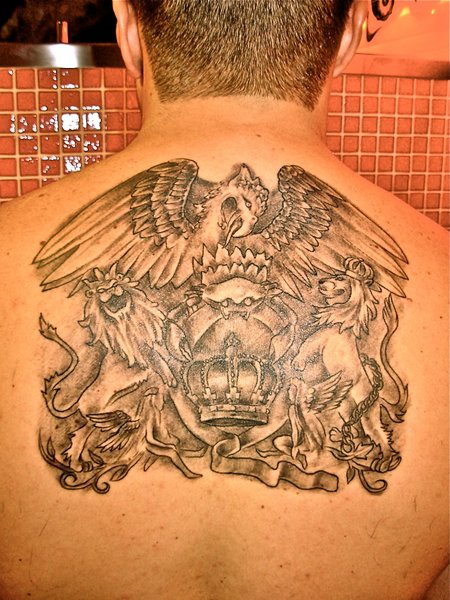 Black And Grey Queen Band Tattoo On Upper Back