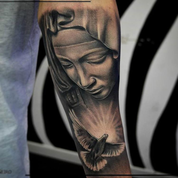 Black And Grey Saint Mary With Flying Bird Tattoo On Forearm