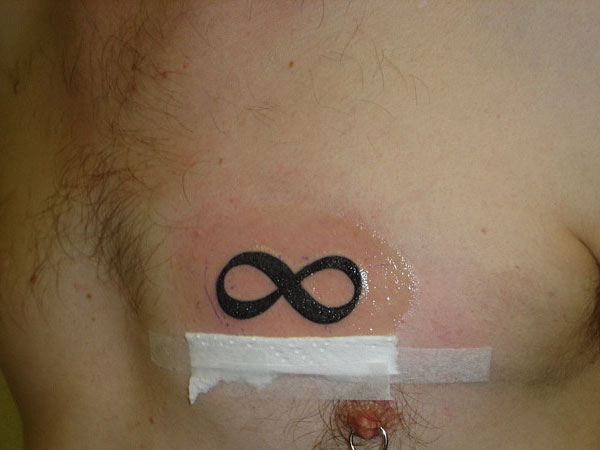 Black Infinity Symbol Tattoo On Man Chest