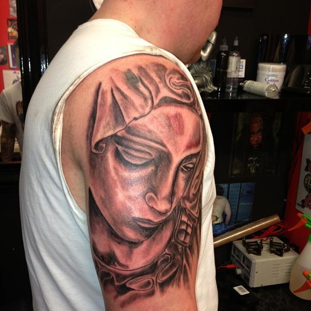 Black Ink Saint Mary Face Tattoo On Right Shoulder