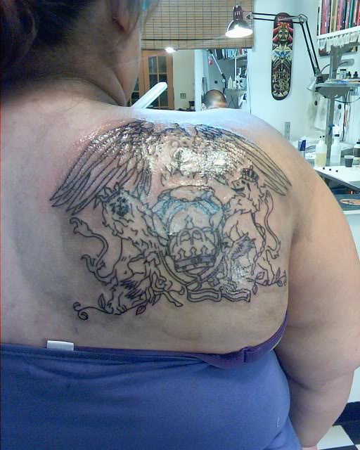 Black Outline Queen Band Tattoo On Girl Right Back Shoulder