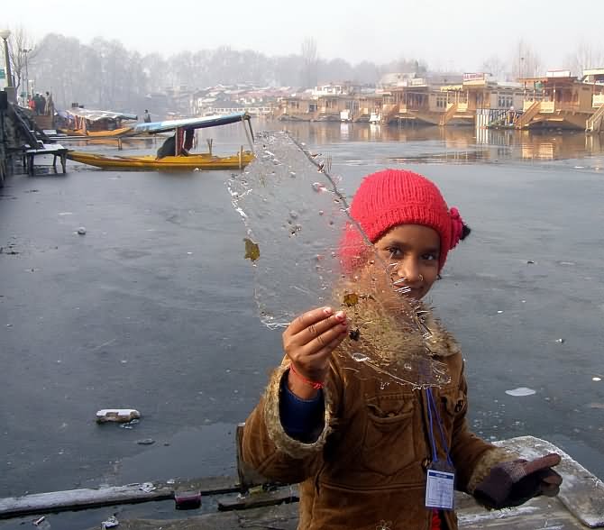 Girl Showing Piece Of Frozen Dal Lake In Winter
